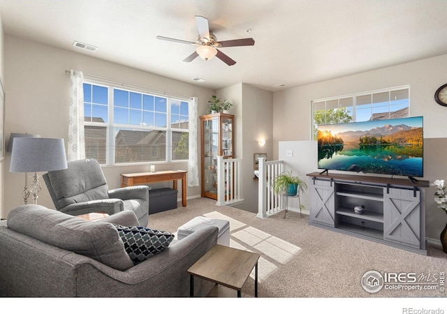 living area featuring ceiling fan, carpet, plenty of natural light, and baseboards