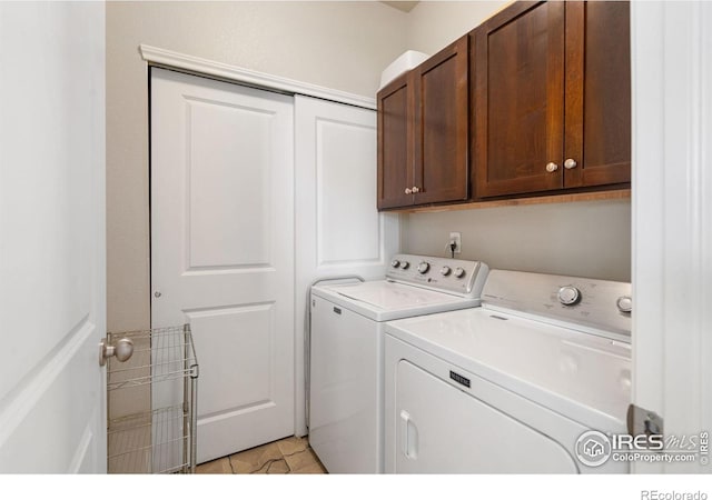 washroom with cabinet space, independent washer and dryer, and light tile patterned floors