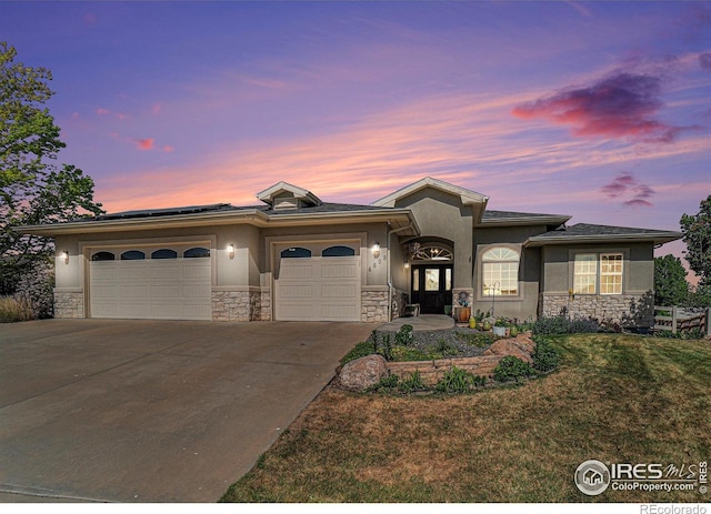 4609 Freehold Dr, Windsor, CO 80550 - view of front of home featuring stone siding, stucco siding, a garage, concrete driveway, and solar panels