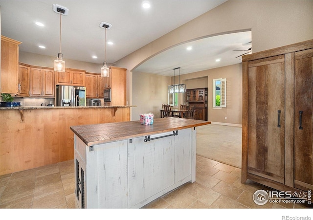 4609 Freehold Dr, Windsor, CO 80550 - kitchen with smart refrigerator, arched walkways, a breakfast bar, ceiling fan, and recessed lighting