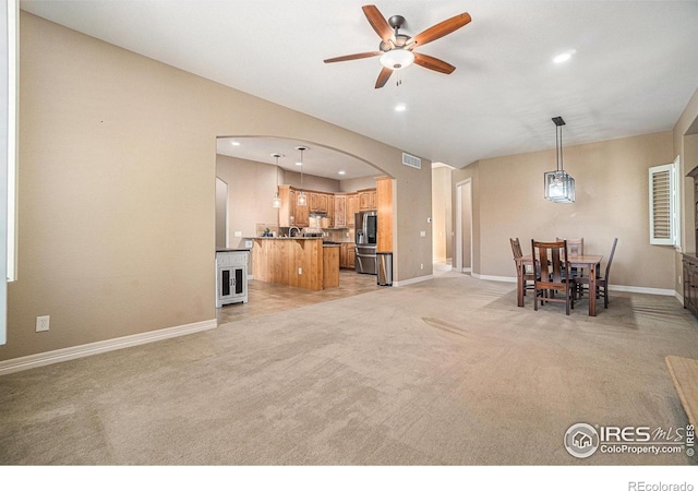 4609 Freehold Dr, Windsor, CO 80550 - living area featuring arched walkways, a ceiling fan, light carpet, and recessed lighting