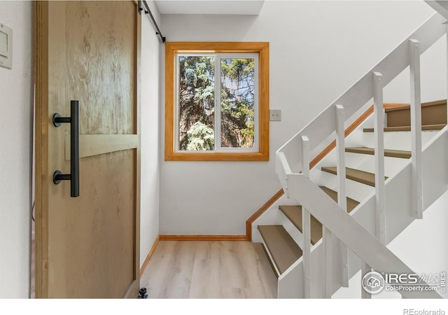 4888 Silver Spruce Ln, Evergreen, CO 80439 - stairs featuring wood finished floors, baseboards, and a barn door
