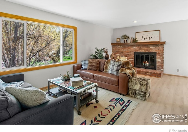 4888 Silver Spruce Ln, Evergreen, CO 80439 - living area with wood finished floors, a brick fireplace, and baseboards
