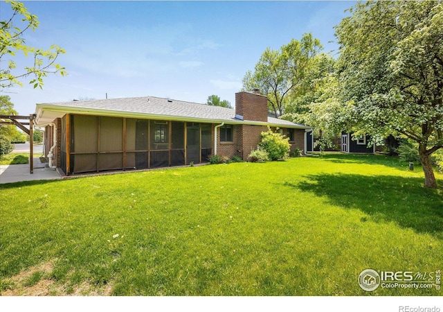 4760 Lee Cir, Boulder, CO 80303 - back of house featuring a lawn, a chimney, and a sunroom
