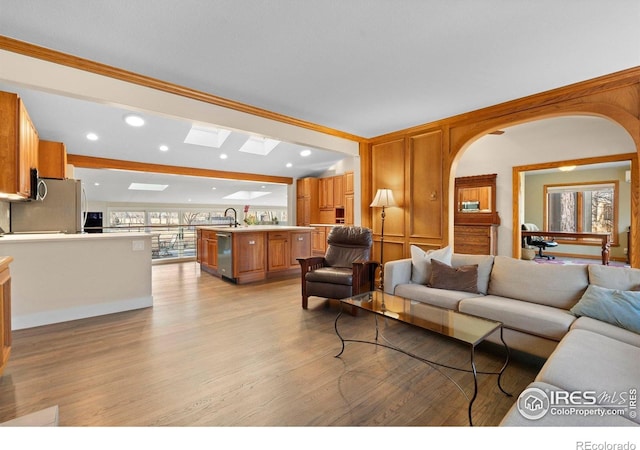819 Gapter Rd, Boulder, CO 80303 - living area with light wood-style flooring, recessed lighting, ornamental molding, arched walkways, and a skylight