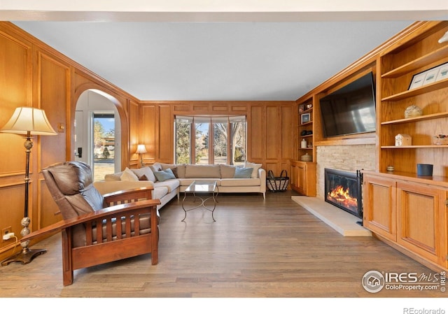 819 Gapter Rd, Boulder, CO 80303 - living room with a stone fireplace, arched walkways, and wood finished floors