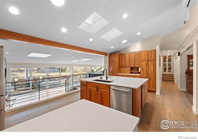 819 Gapter Rd, Boulder, CO 80303 - kitchen featuring stainless steel dishwasher, a sink, a kitchen island with sink, a skylight, and light wood-style floors
