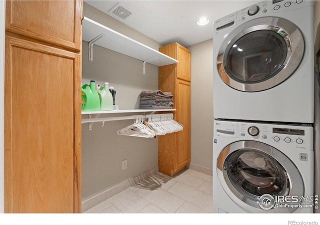 819 Gapter Rd, Boulder, CO 80303 - clothes washing area with stacked washer / dryer, cabinet space, light tile patterned floors, and baseboards