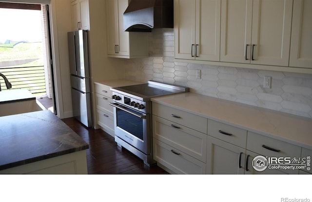 410 Superior Dr, Superior, CO 80027 - kitchen with appliances with stainless steel finishes, wall chimney range hood, tasteful backsplash, dark wood finished floors, and a sink
