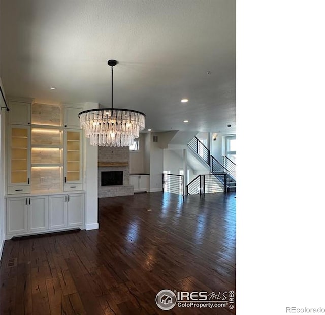 410 Superior Dr, Superior, CO 80027 - unfurnished living room with dark wood finished floors, a chandelier, recessed lighting, healthy amount of natural light, and baseboards