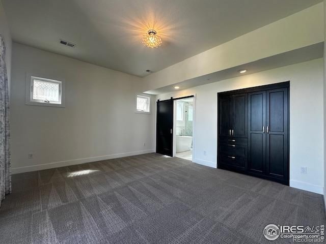410 Superior Dr, Superior, CO 80027 - unfurnished bedroom with carpet, a barn door, multiple windows, and recessed lighting