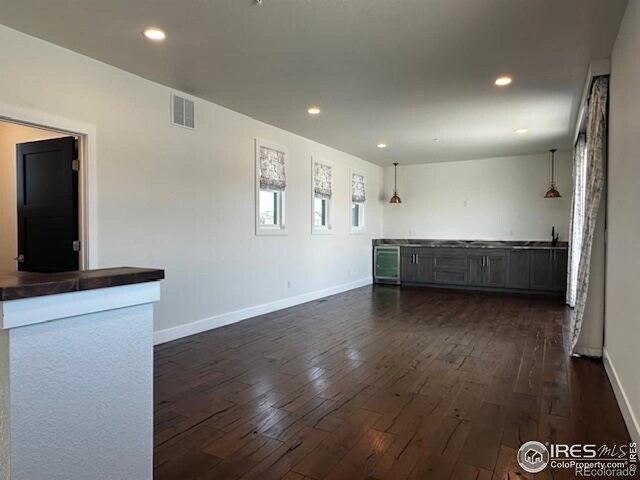 410 Superior Dr, Superior, CO 80027 - spare room featuring dark wood-style floors, baseboards, recessed lighting, and bar area