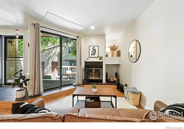 5016 Buckingham Rd Unit 4, Boulder, CO 80301 - living room featuring wood finished floors, a tiled fireplace, and a textured ceiling