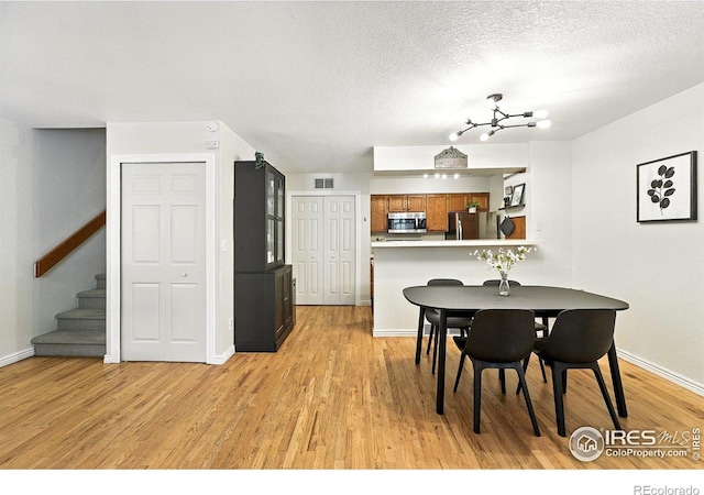 5016 Buckingham Rd Unit 4, Boulder, CO 80301 - dining space featuring light wood-style floors, stairs, and a textured ceiling