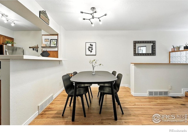 5016 Buckingham Rd Unit 4, Boulder, CO 80301 - dining area with light wood finished floors, rail lighting, and a chandelier