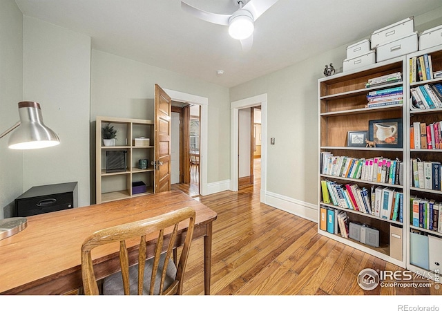 office space with wood finished floors, a ceiling fan, and baseboards