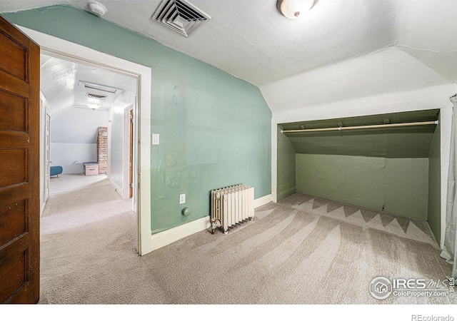 additional living space featuring radiator heating unit, lofted ceiling, light carpet, and baseboards