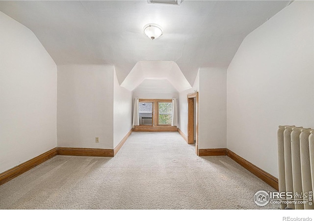 additional living space featuring radiator, carpet floors, lofted ceiling, baseboards, and cooling unit