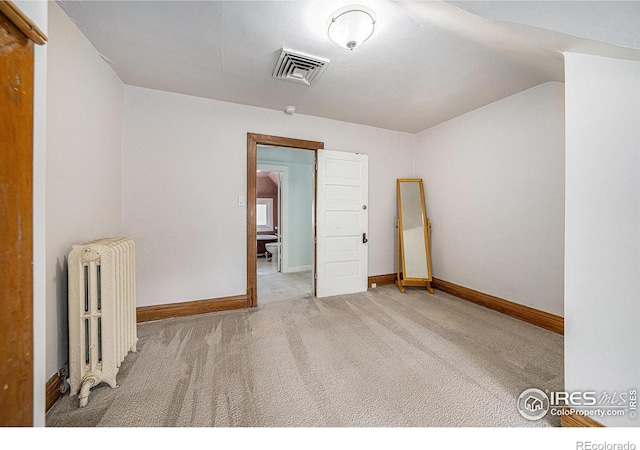 unfurnished room with radiator heating unit, carpet, baseboards, and lofted ceiling