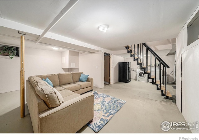 living area with stairs, concrete floors, and washer / clothes dryer
