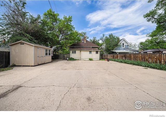 exterior space featuring a patio, fence, and an outbuilding