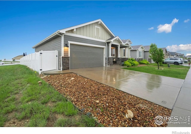 view of front of property with board and batten siding, an attached garage, stone siding, and concrete driveway