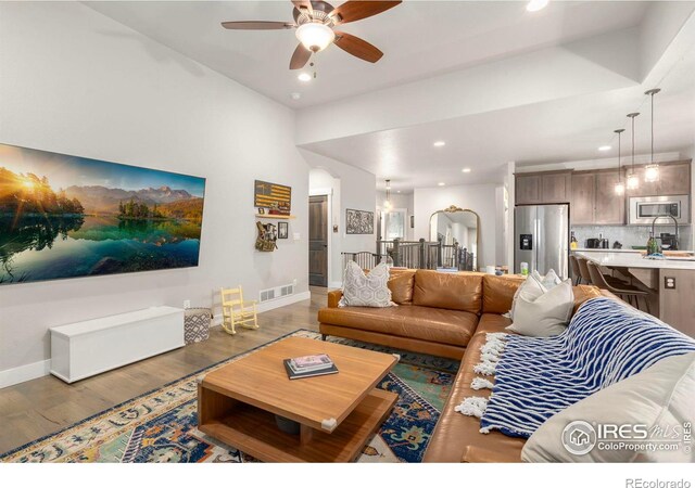 living area with ceiling fan, recessed lighting, wood finished floors, and baseboards