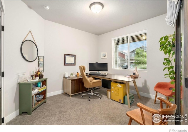 carpeted home office featuring baseboards