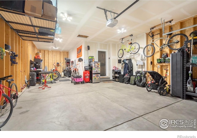 garage featuring a garage door opener and wood walls