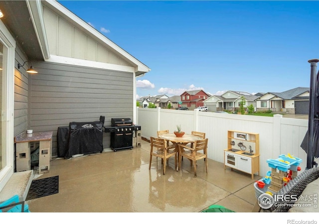 view of patio / terrace featuring a grill, a residential view, fence, and outdoor dining space