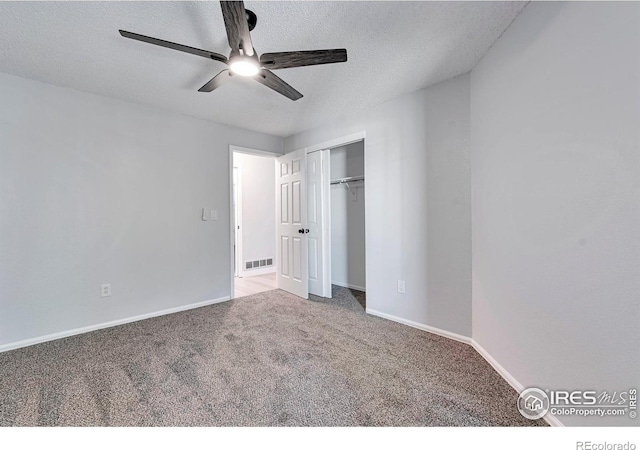12525 E Tennessee Cir Unit E, Aurora, CO 80012 - unfurnished bedroom featuring carpet floors, a textured ceiling, baseboards, a closet, and a ceiling fan