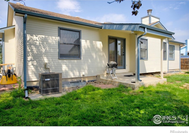 rear view of property with central AC, a patio area, and a chimney