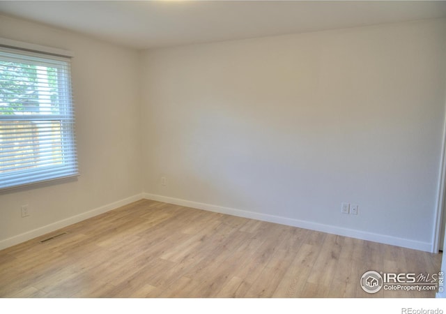 empty room featuring light wood-style flooring and baseboards