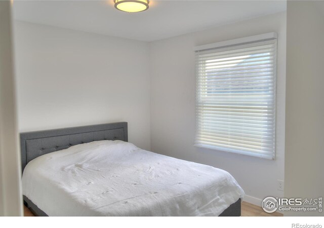bedroom featuring baseboards and wood finished floors