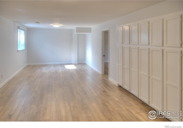spare room featuring light wood-style floors and baseboards