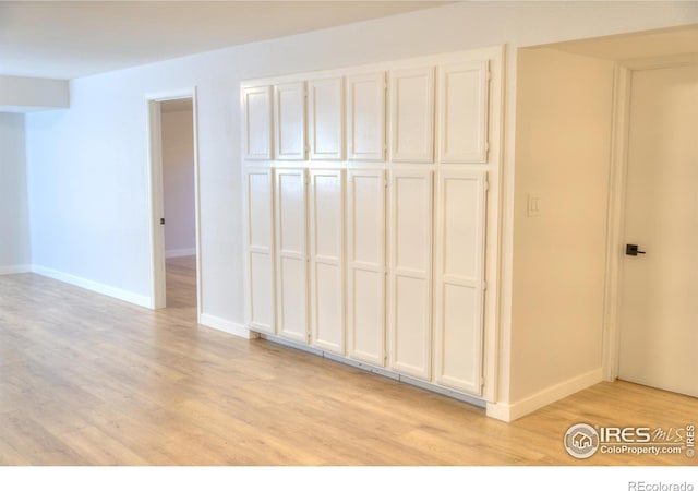 unfurnished bedroom with light wood-style flooring and baseboards