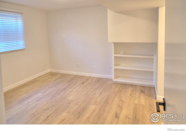 bonus room featuring light wood-type flooring and baseboards