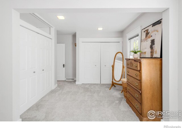 bedroom with light carpet and a closet