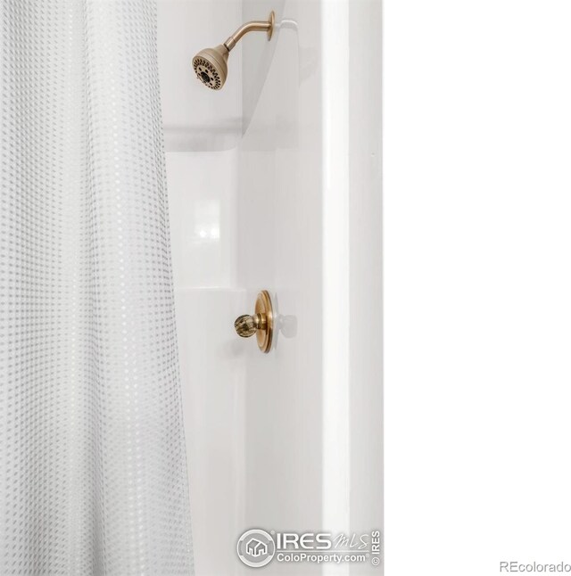 bathroom view of a shower with shower curtain