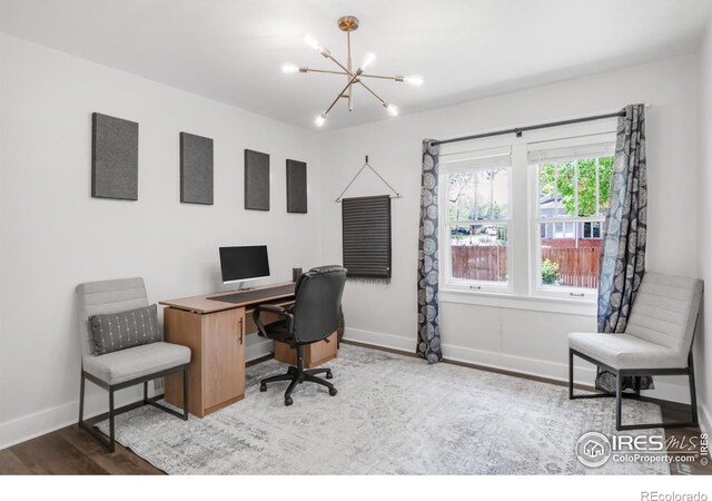 home office with a chandelier, wood finished floors, and baseboards