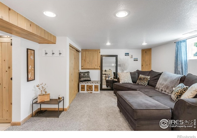 living room featuring light carpet, recessed lighting, and a textured ceiling