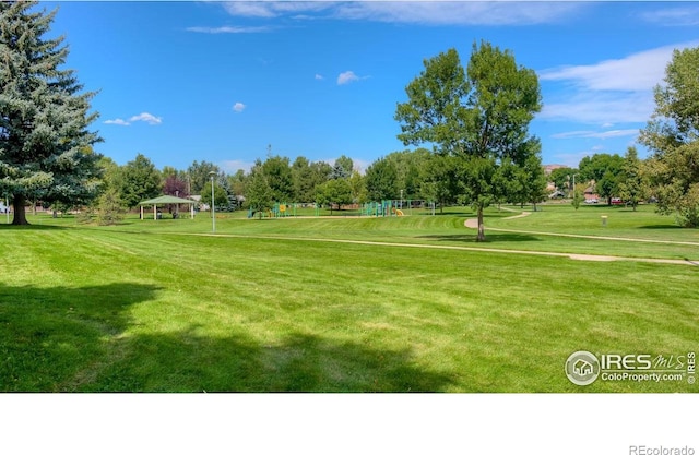 view of community featuring a gazebo, a lawn, and view of scattered trees