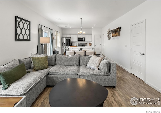 living area featuring a chandelier, dark wood-style flooring, baseboards, and recessed lighting