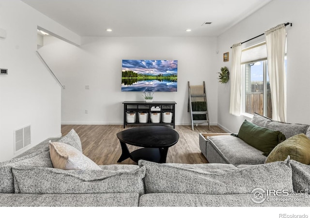living room featuring wood finished floors, recessed lighting, and baseboards