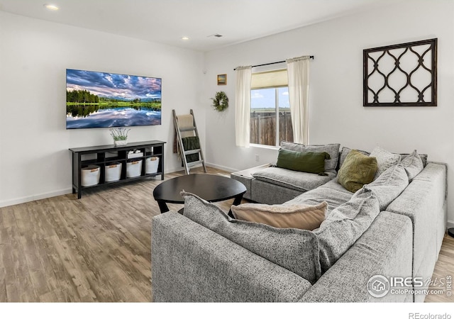 living room with wood finished floors, baseboards, and recessed lighting