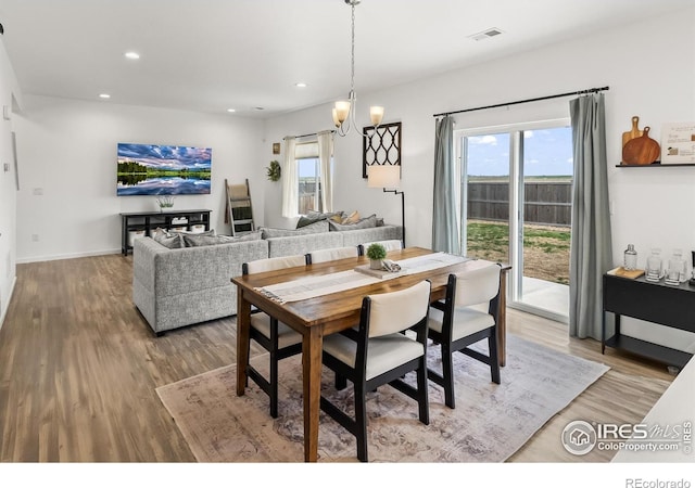 dining room with recessed lighting, light wood-type flooring, a chandelier, and baseboards