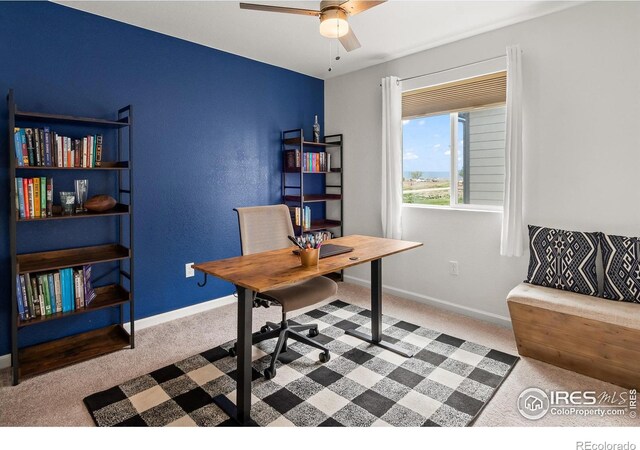 office space featuring carpet flooring, a ceiling fan, and baseboards