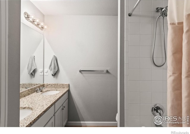 bathroom featuring shower / bathtub combination with curtain, double vanity, toilet, and baseboards