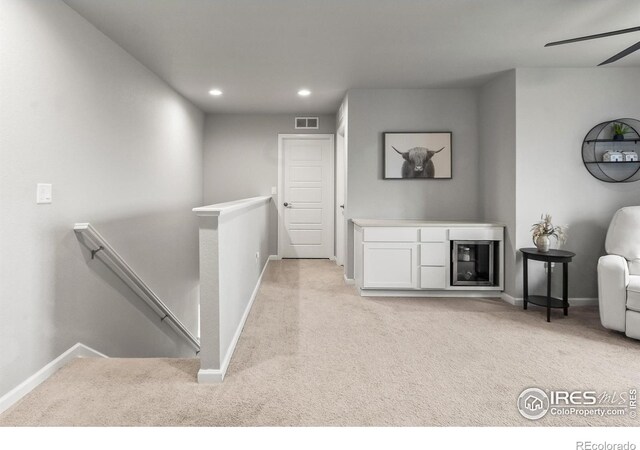 hallway featuring an upstairs landing, light colored carpet, baseboards, and recessed lighting