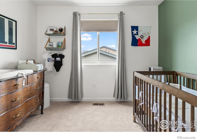 carpeted bedroom with a nursery area and baseboards